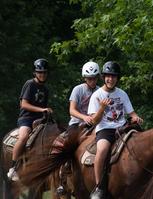 Three boys on horseback.